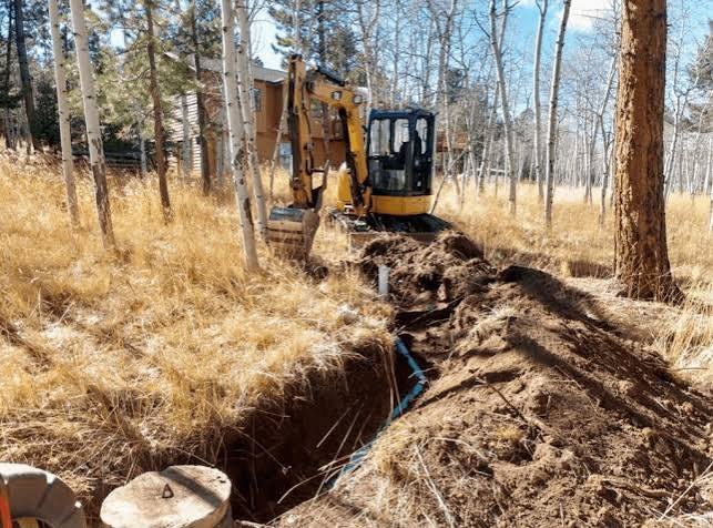 Excavator digging trenches for drainage pipes