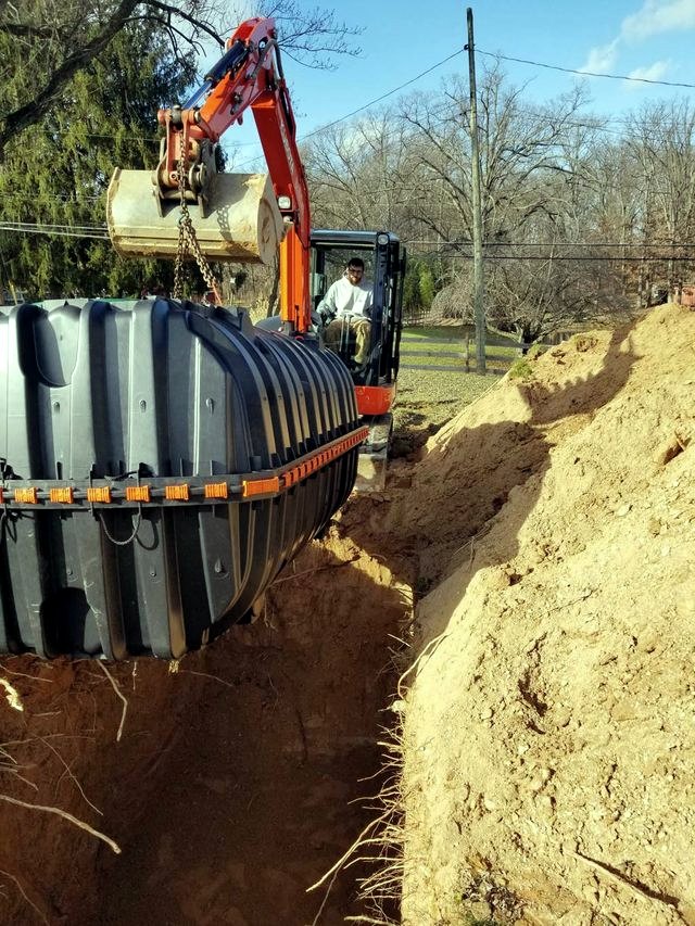 Crane installing underground water storage tank
